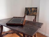 a wooden table with a chair and a book on it
