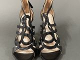 a pair of women ' s black and white sandals on a gray surface