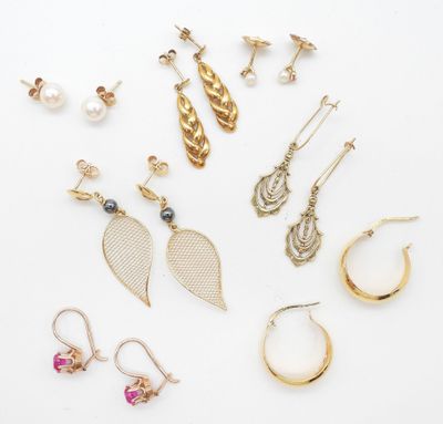 an assortment of earrings and rings on a white surface