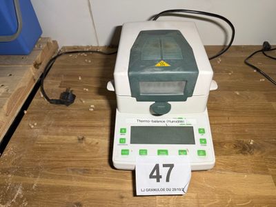 une photo d'une balance numérique posée sur une table en bois