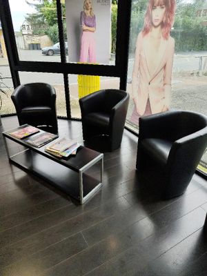 two black chairs and a coffee table in a room