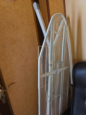 un ventilateur posé à côté d'une chaise dans un coin de la pièce