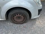 a car that has a flat tire on the side of the road