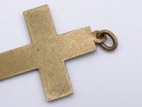 a gold cross that is on a white surface