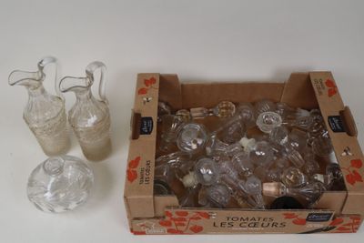une boîte remplie de vases en verre à côté d'une boîte de vases en verre vides