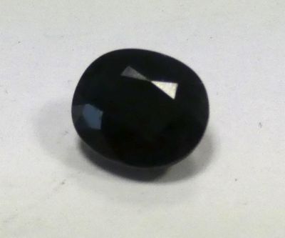 a close up of a black stone on a white surface