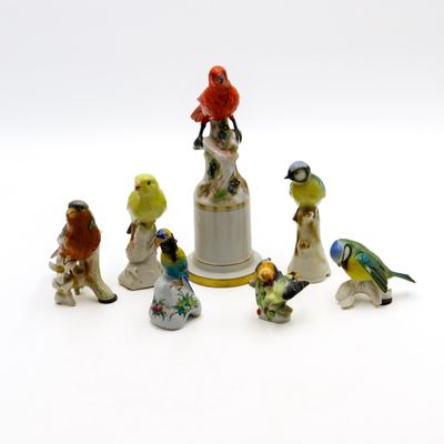 plusieurs figurines d'oiseaux sont perchées sur une cloche