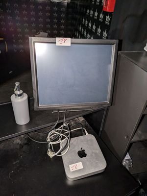 un ordinateur Apple posé sur un bureau, à côté d'une poubelle