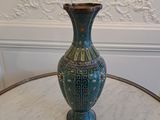 a blue vase sitting on a table in a room