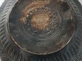 a black plate with a lion on it on a white surface