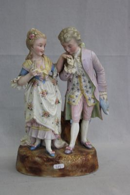 une figurine représentant deux personnes debout l'une à côté de l'autre