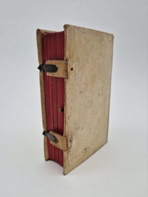 un vieux livre à la couverture rouge posé sur une surface blanche