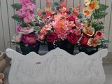 une jardinière blanche posée par terre et remplie de fleurs