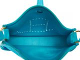 the inside of a blue purse with a gold handle