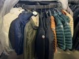 de nombreuses vestes suspendues à un portant dans un magasin