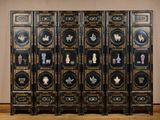 un paravent sur lequel sont disposés plusieurs vases