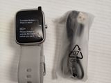 a smart watch sitting next to a charger on a table