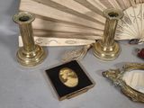 a fan, a mirror, a mirror, and other items that are on a table