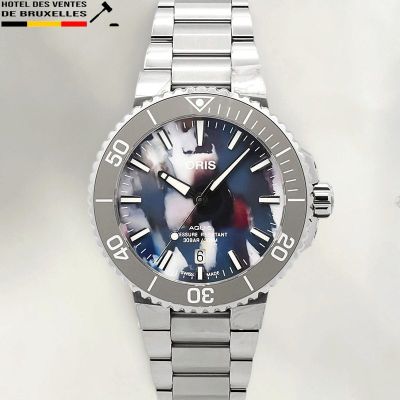 un gros plan d'une montre au cadran bleu montée sur un bracelet argenté