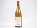 une bouteille de vin blanc posée sur une table blanche