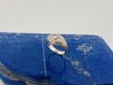 un gros plan d'une bague posée sur une pierre bleue