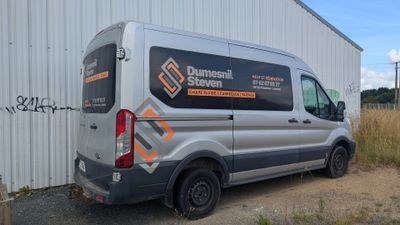 une camionnette garée devant un immeuble, sur laquelle on voit des graffitis