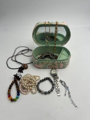 une boîte sur laquelle sont posés un collier, des bracelets et d'autres objets