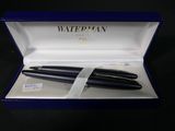 two black fountain pens in a blue box with a white ribbon