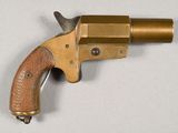 an old brass revolver with a wooden handle on a white surface