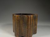 a brown vase sitting on top of a white table