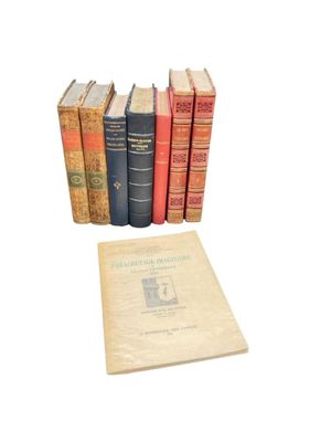 several old books are stacked on top of each other on a white surface