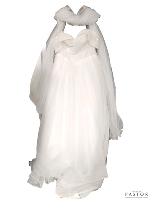 une robe de mariée suspendue à un cintre accroché au mur