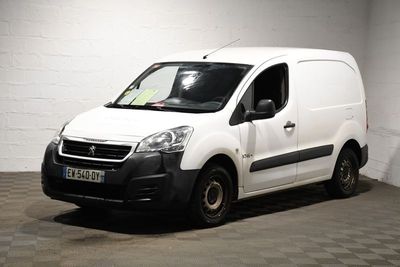 La petite camionnette blanche est garée dans une grande pièce.