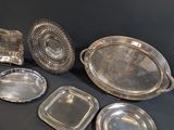 several silver trays and trays on a table with a black background