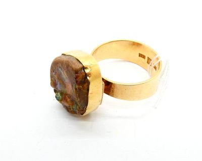 bague en or jaune sertie d'une pierre brune au centre