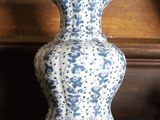 a blue and white vase sitting on a wooden shelf