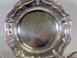 a silver plate with a silver teapot on it