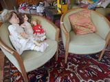 deux chaises sur lesquelles sont assises des poupées, dans un salon