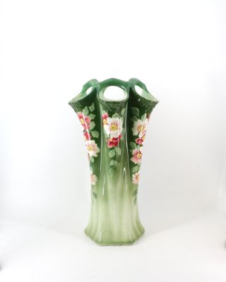 un vase vert orné de fleurs roses sur fond blanc