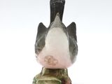 a black and white bird sitting on top of a vase