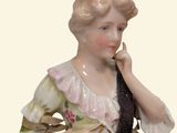a figurine of a woman sitting on a chair