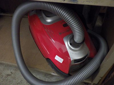 a red and silver vacuum that is sitting in a box