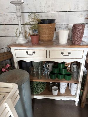 a small table with pots and vases on top of it