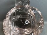 une figurine de Bouddha en verre posée sur une table