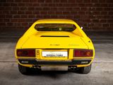 the rear end of a yellow sports car parked in a garage