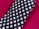 a close up of a neck tie on a pink surface