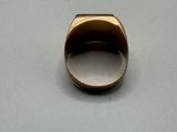 a close up of a gold ring on a white surface