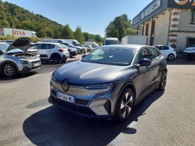 une voiture grise garée dans un parking à côté d'un bâtiment