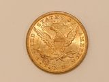 a close up of a gold coin on a white surface