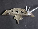 a silver brooch with a star on it on a black surface